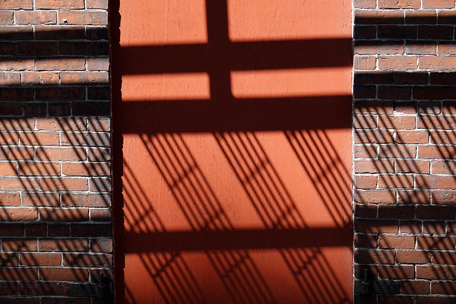 Fire escape shadow on brick wall