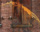 paint-spash-against-steel-shutters-on-brick-Lewiston_DSC01471